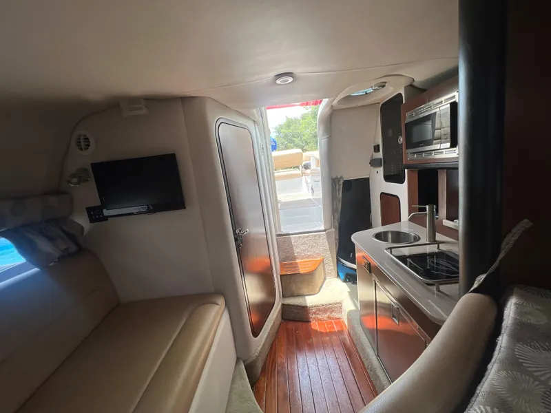 Slide: The Image of Interior of 2017 Crownline 294 CR boat with kitchenette, seating, and TV. - 39