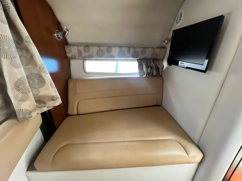 Slide: The Image of 2017 Crownline 294 CR cabin interior with beige seating and wall-mounted TV. - 40