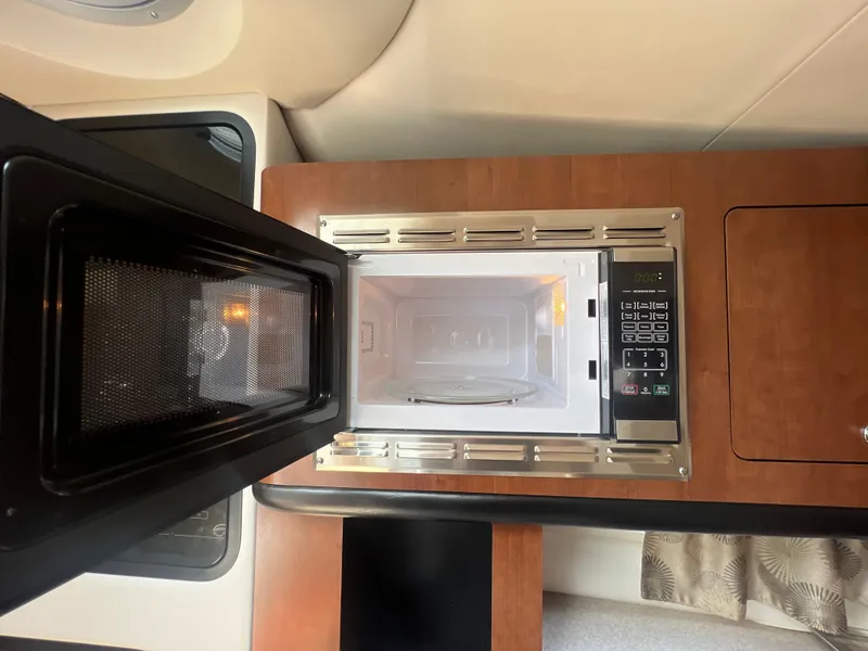 Slide: The Image of Microwave in 2017 Crownline 294 CR boat interior, featuring wood finish and modern design. - 46