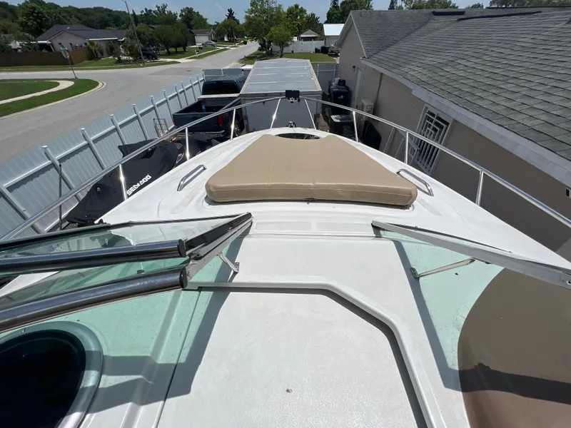 Slide: The Image of 2017 Crownline 294 CR boat deck with sunpad, parked in residential area. - 72