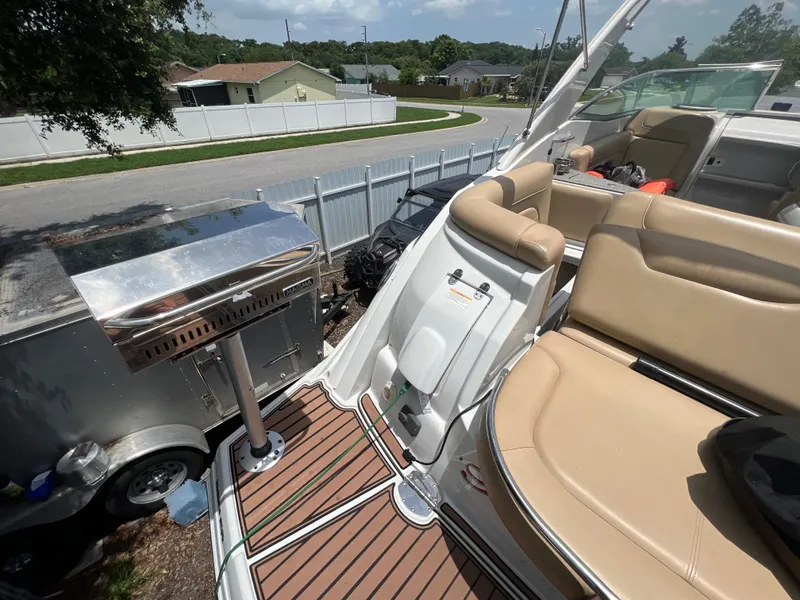 Slide: The Image of 2017 Crownline 294 CR boat with tan seating and stainless steel grill on deck. - 78