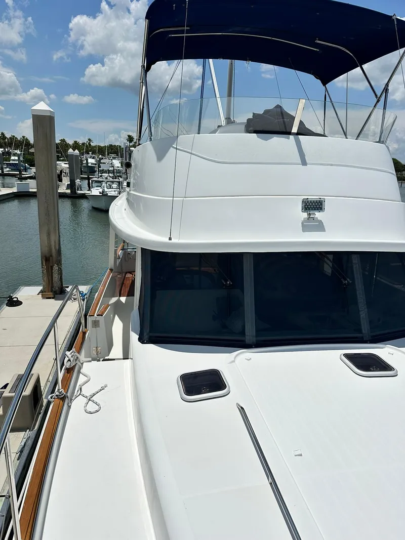 Slide: The Image of 2005 Beneteau Swift Trawler 42 docked at marina under blue sky. - 16