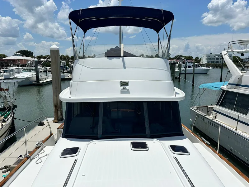 Slide: The Image of 2005 Beneteau Swift Trawler 42 docked at a marina under a clear sky. - 17