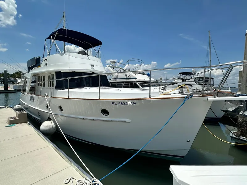 Slide: The Image of 2005 Beneteau Swift Trawler 42 docked at marina under clear blue sky. - 2