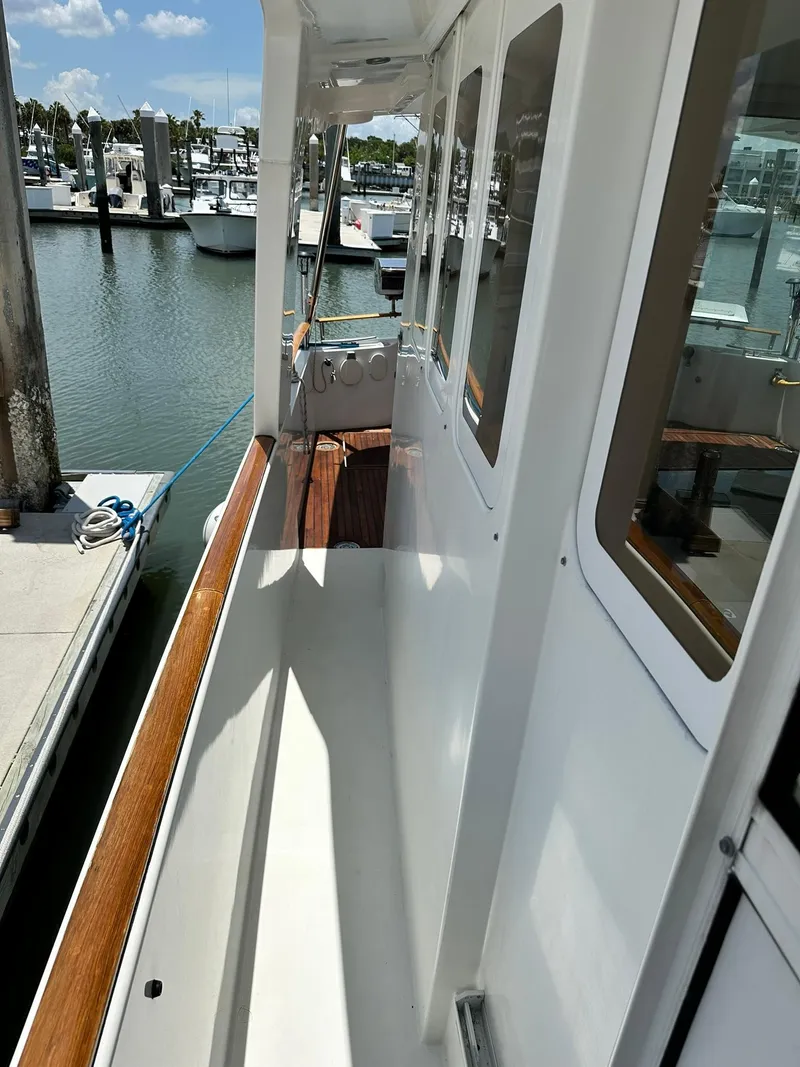 Slide: The Image of 2005 Beneteau Swift Trawler 42 docked, showcasing side deck and marina view. - 21