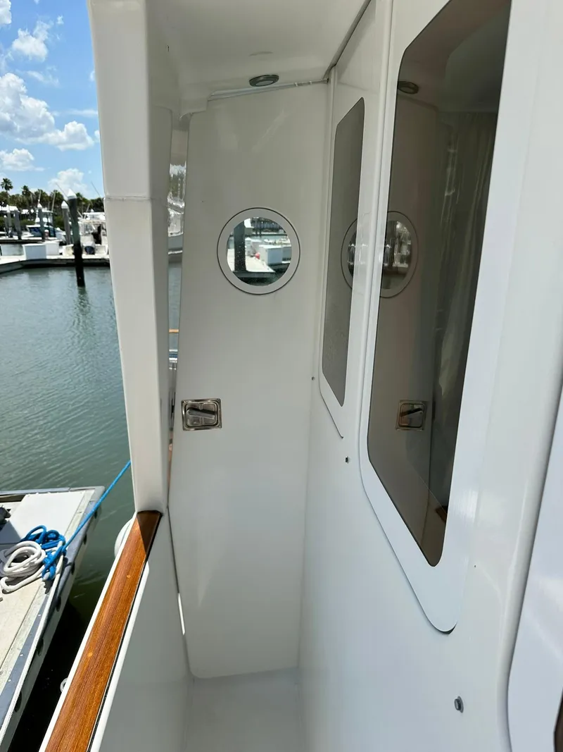 Slide: The Image of 2005 Beneteau Swift Trawler 42 exterior walkway with porthole, docked at marina. - 22
