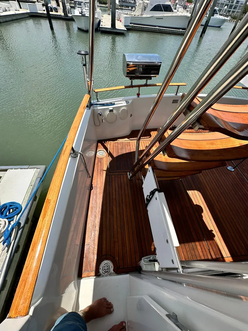 Slide: The Image of 2005 Beneteau Swift Trawler 42 with wooden deck, docked at marina. - 24