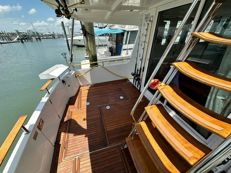 Slide: The Image of 2005 Beneteau Swift Trawler 42, wooden deck and stairs, docked at marina. - 25