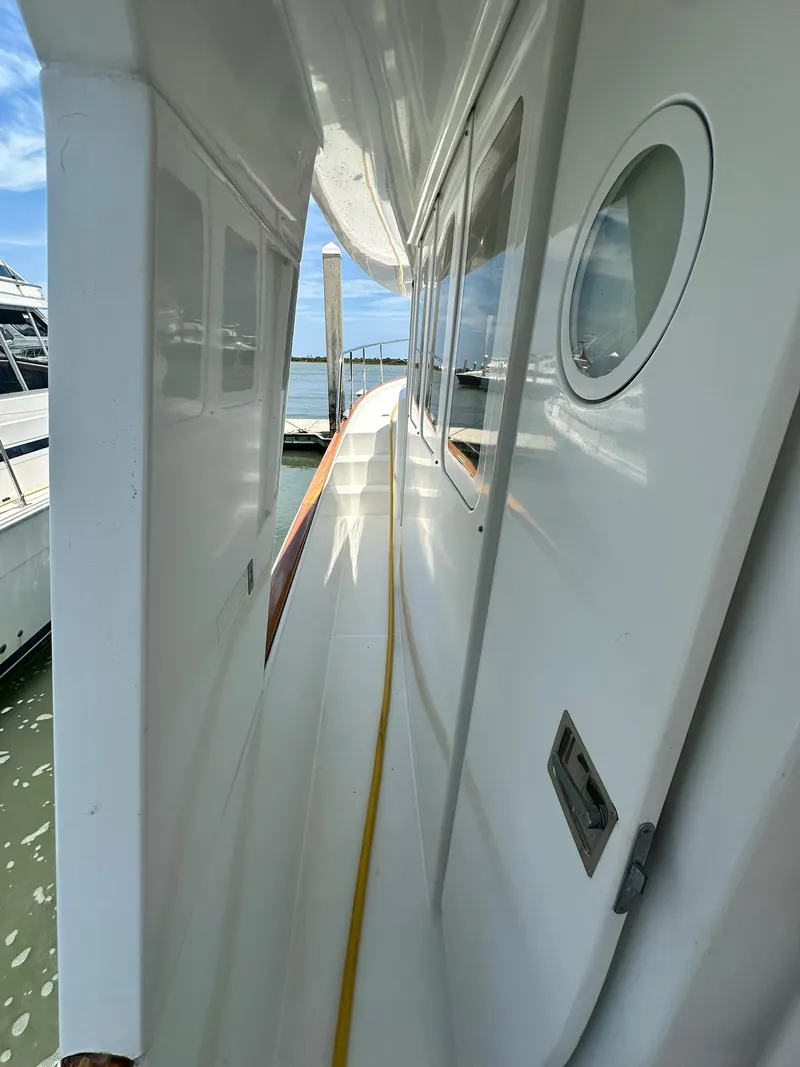 Slide: The Image of 2005 Beneteau Swift Trawler 42 side deck view, showcasing sleek design and porthole window. - 29