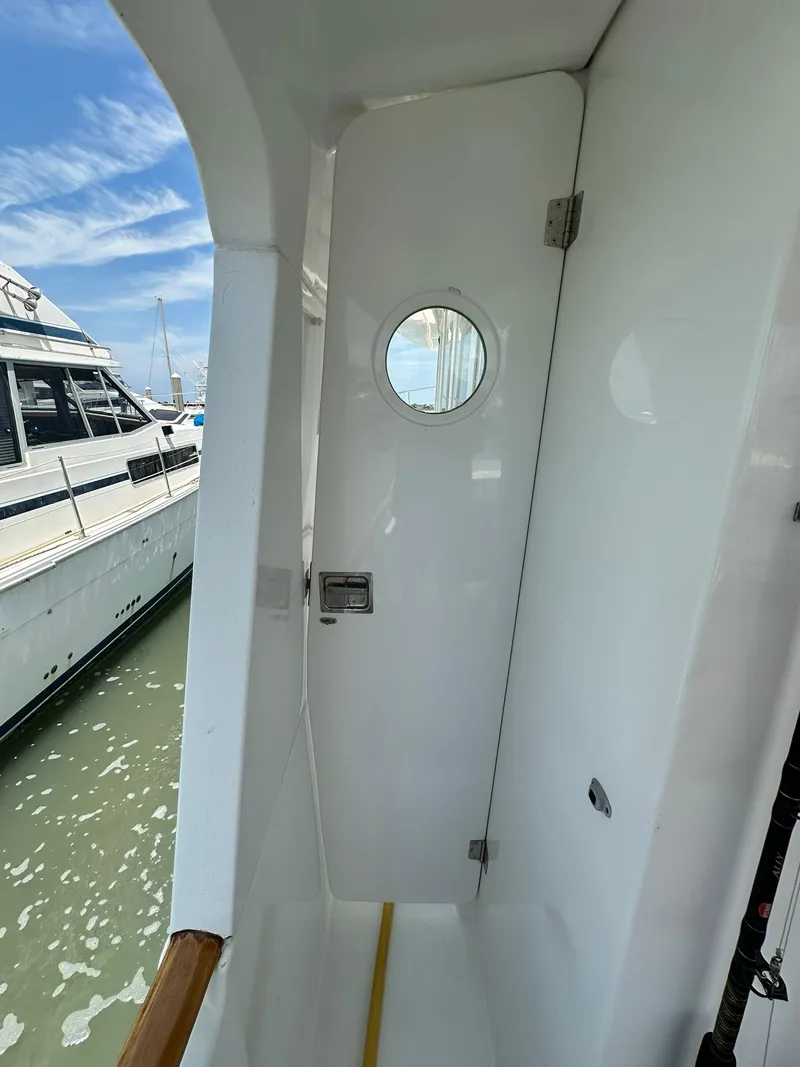 Slide: The Image of 2005 Beneteau Swift Trawler 42, exterior view with porthole and docked boats. - 30