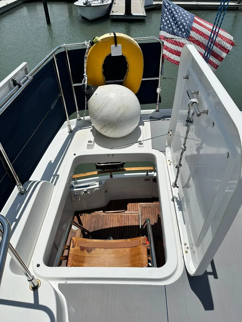 Slide: The Image of 2005 Beneteau Swift Trawler 42 deck with open hatch, life preserver, and American flag. - 39