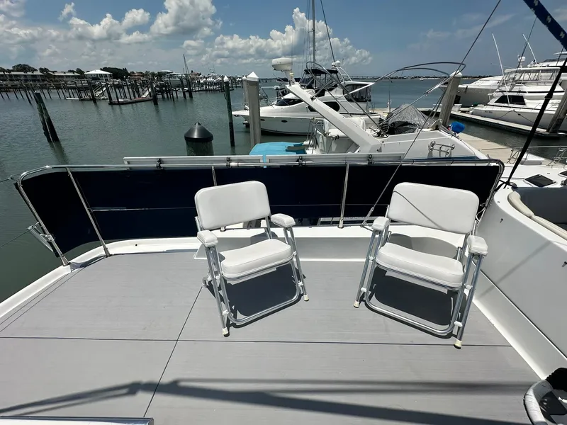 Slide: The Image of 2005 Beneteau Swift Trawler 42 deck with two chairs, marina view. - 40