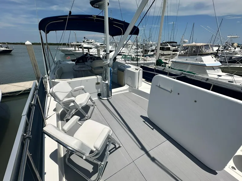 Slide: The Image of 2005 Beneteau Swift Trawler 42 on deck, featuring seating and marina view. - 41