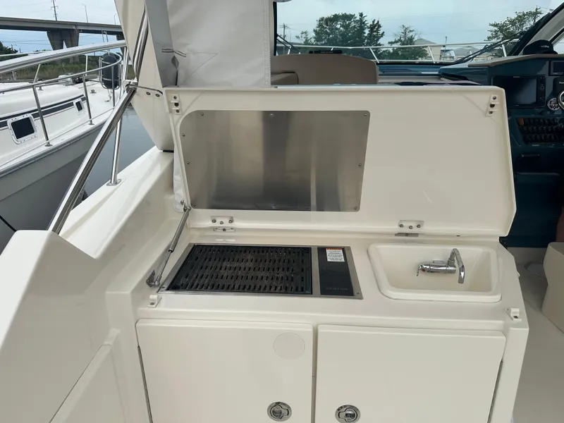 Slide: The Image of 2014 Pursuit SC 365i Sport Coupe boat with outdoor kitchenette and sink. - 14