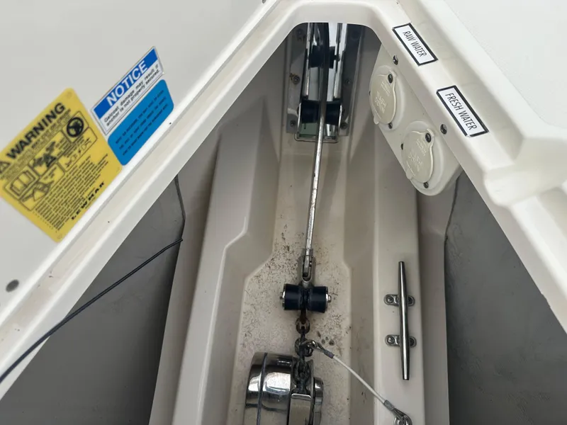 Slide: The Image of Anchor compartment of 2014 Pursuit SC 365i Sport Coupe with warning labels and chain mechanism. - 26