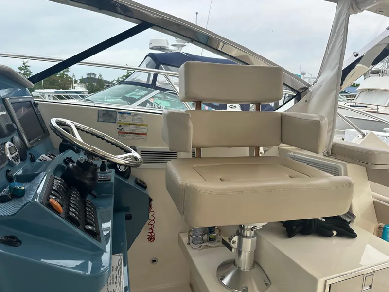 Slide: The Image of Helm of 2014 Pursuit SC 365i Sport Coupe with beige captain's chair and control panel. - 32