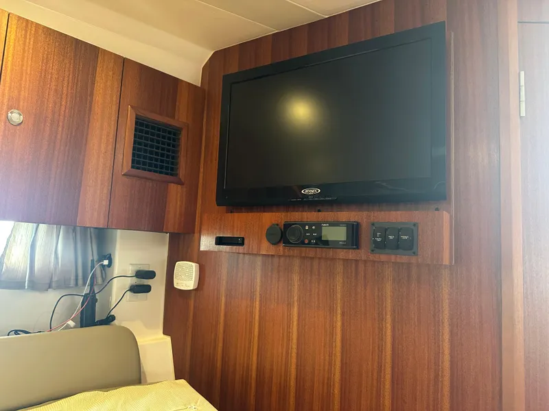 Slide: The Image of 2014 Pursuit SC 365i Sport Coupe interior with mounted TV and control panel. - 42