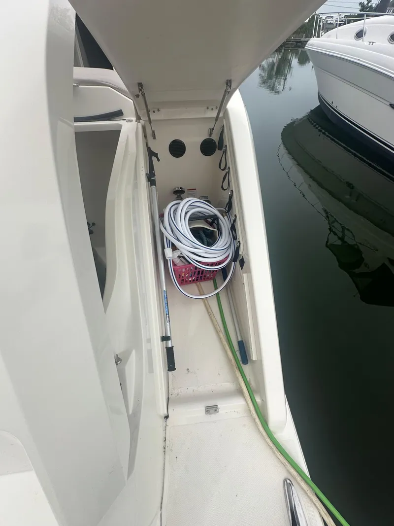 Slide: The Image of 2014 Pursuit SC 365i Sport Coupe storage compartment with coiled hoses and equipment. - 49