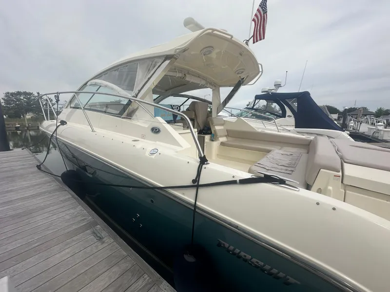 Slide: The Image of 2014 Pursuit SC 365i Sport Coupe docked, featuring sleek design and American flag. - 5