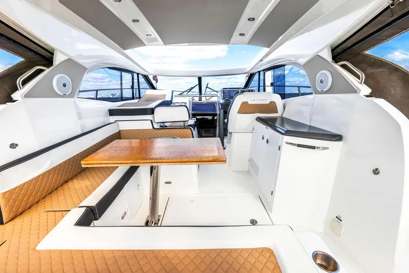 Slide: The Image of 2018 Jeanneau Leader 36 interior with seating, table, and helm, showcasing luxury yacht design. - 5
