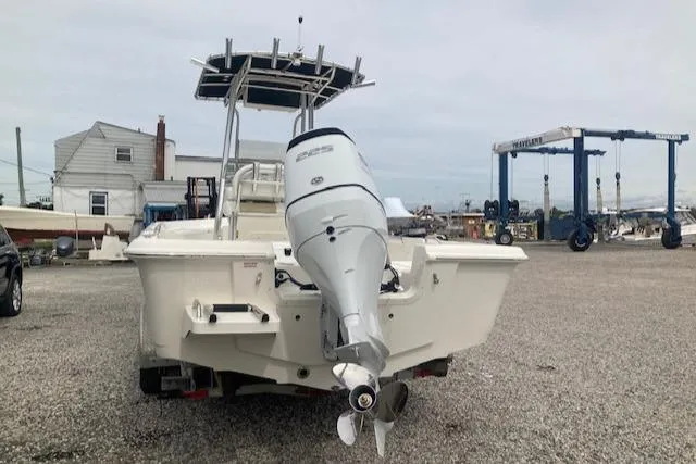 Slide: The Image of 2023 Bulls Bay 2400 boat with outboard motor, parked on gravel lot. - 2