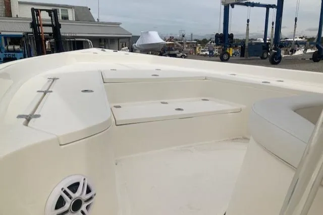Slide: The Image of 2023 Bulls Bay 2400 boat interior with seating and speaker, dockside view. - 4