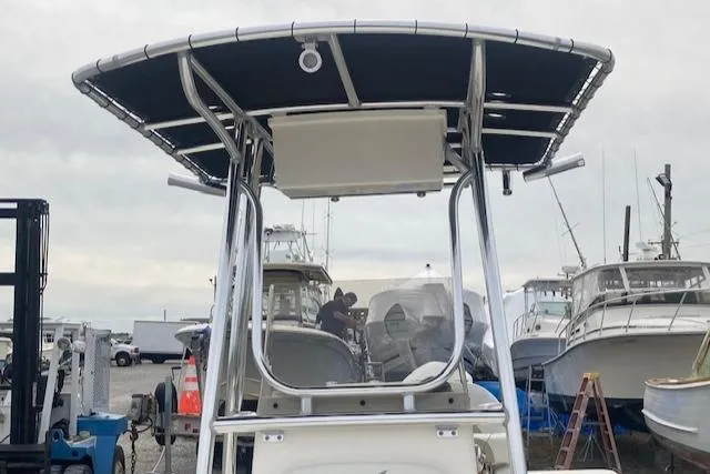 Slide: The Image of 2023 Bulls Bay 2400 boat with T-top, docked among other vessels. - 6