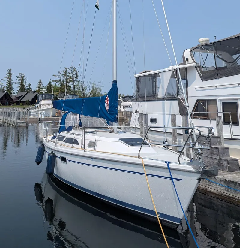 The Image of 1997 Catalina 28 MKII sailboat docked in a marina, featuring blue sail cover. - 0