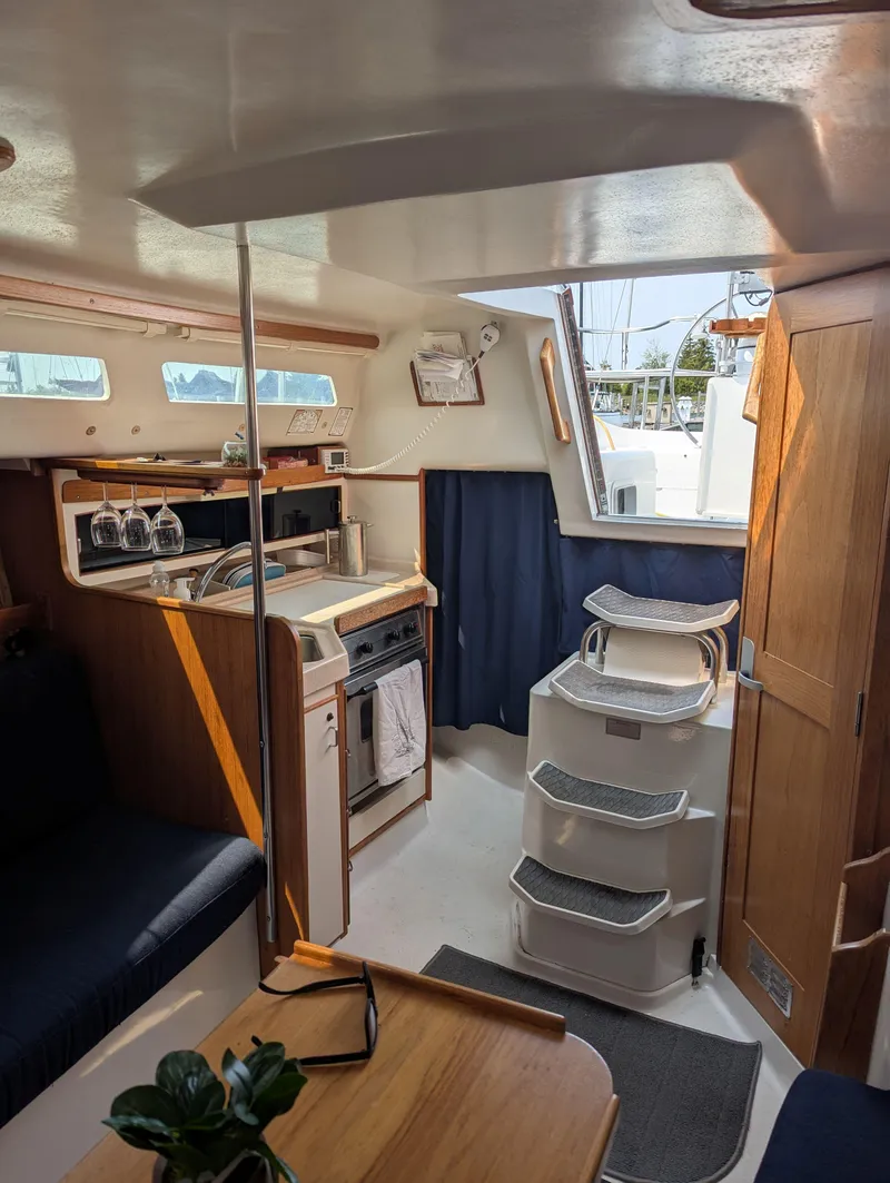 Slide: The Image of Interior of a 1997 Catalina MkII sailboat with kitchen and seating area. - 6