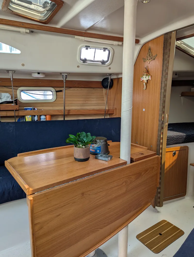Slide: The Image of Interior of a 1997 Catalina MkII sailboat with wooden table and cozy seating. - 8