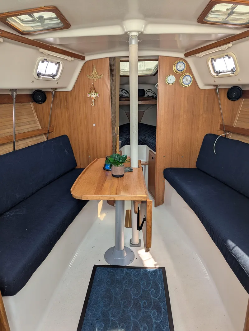 Slide: The Image of Interior of a 1997 Catalina MkII sailboat with wooden accents and navy seating. - 9