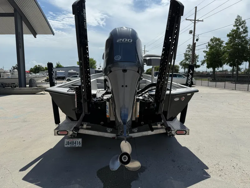 Slide: The Image of Avid FS23 Mag Platinum 2021 boat, interior view with console and seating, parked outdoors. - 6