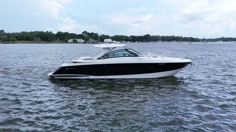The Image of 2015 Cobalt A40 boat on calm water, side view, under a partly cloudy sky. - 0