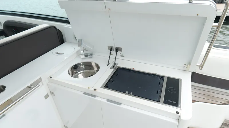 Slide: The Image of 2015 Cobalt A40 yacht kitchenette with sink and stove, open storage compartment. - 26