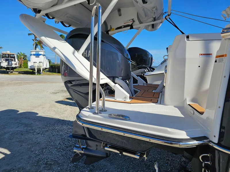 Slide: The Image of 2023 Ranger Tugs 27R boat with dual outboard motors, docked under clear blue sky. - 10