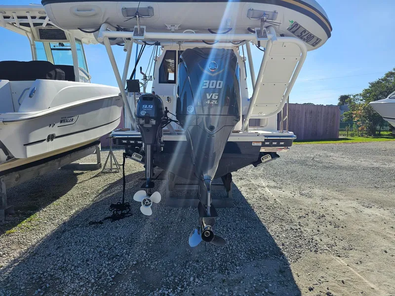 Slide: The Image of 2023 Ranger Tugs 27R boat with powerful outboard motor in a sunny marina. - 11