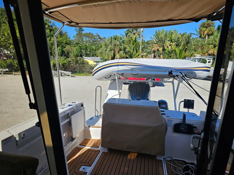 Slide: The Image of 2023 Ranger Tugs 27R boat interior with covered seating and outdoor view. - 14