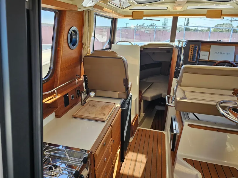 Slide: The Image of Interior of 2023 Ranger Tugs 27R boat, featuring wood accents and modern amenities. - 15
