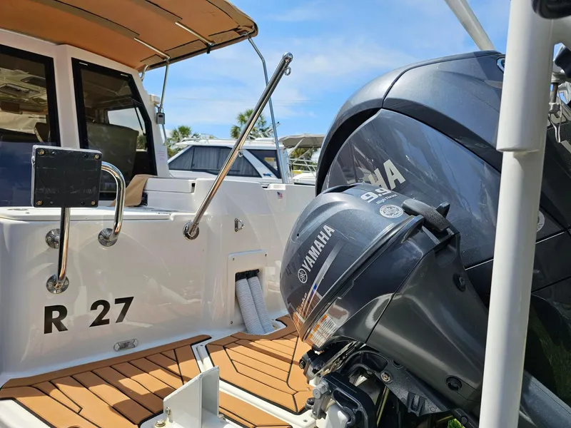 Slide: The Image of 2023 Ranger Tugs 27R boat with Yamaha outboard motor, docked under clear blue sky. - 9
