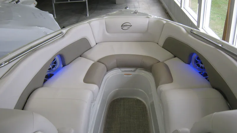 Slide: The Image of 2015 Crownline 285 SS boat interior with cushioned seating and blue accent lighting. - 20