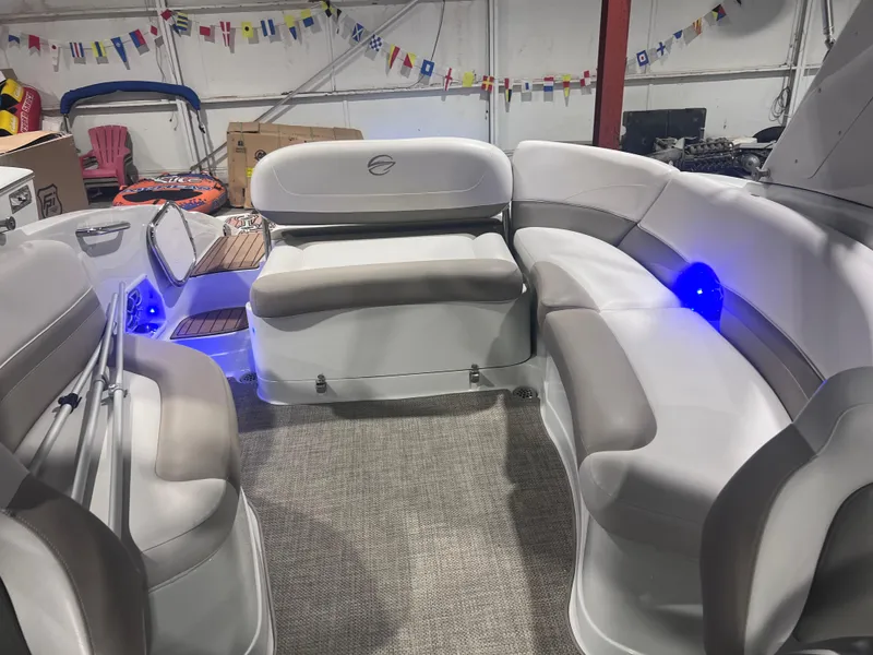 Slide: The Image of 2015 Crownline 285 SS boat interior with plush seating and ambient blue lighting. - 28