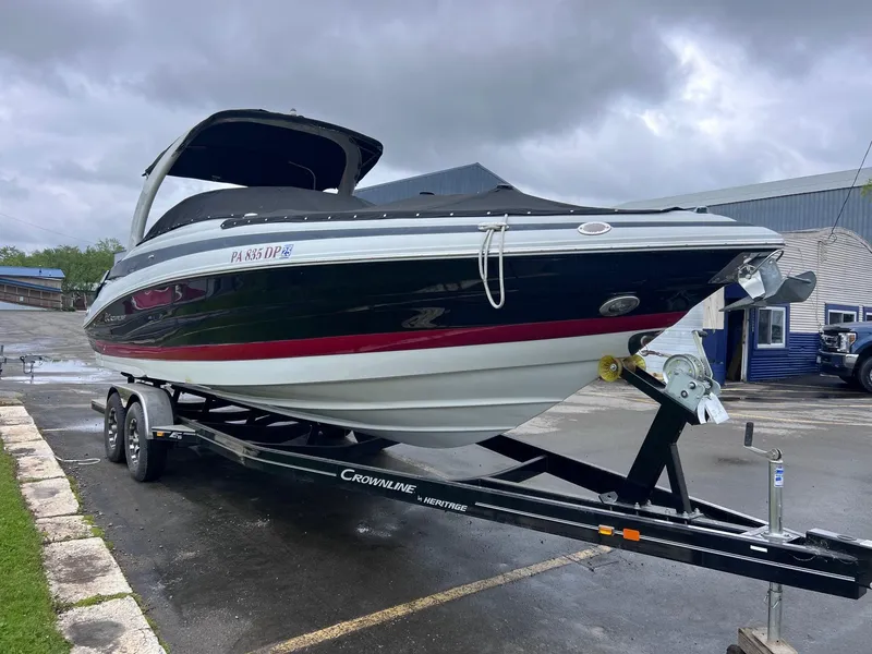 Slide: The Image of 2015 Crownline 285 SS boat on trailer, parked outdoors under cloudy skies. - 3