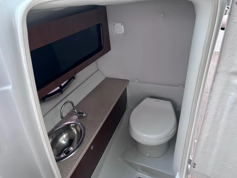 Slide: The Image of 2015 Crownline 285 SS boat interior with sink and toilet. - 9