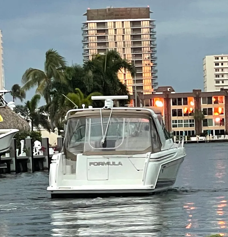 Slide: The Image of 2001 Formula 41 PC boat cruising near waterfront buildings and palm trees. - 1