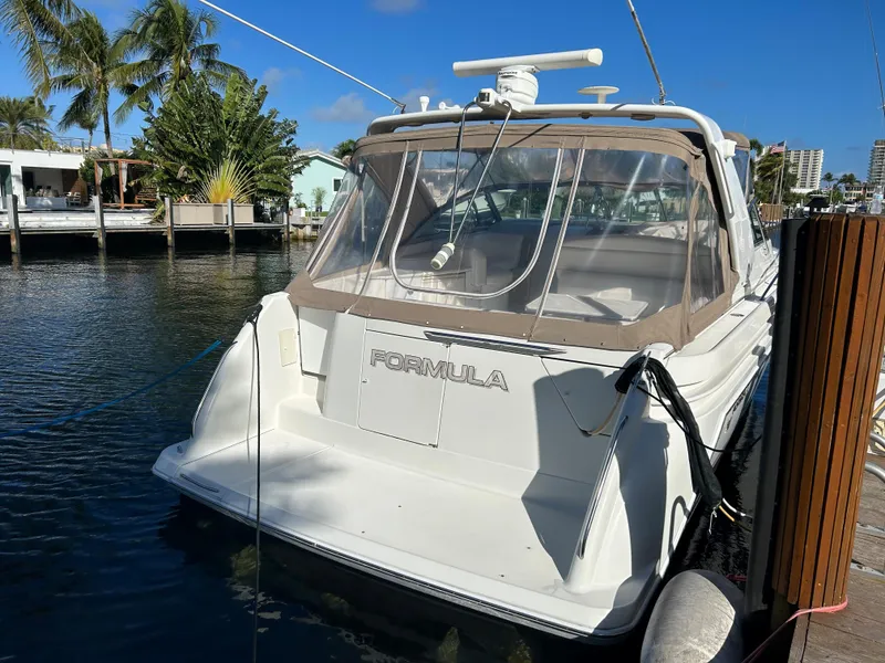 Slide: The Image of 2001 Formula 41 PC yacht docked by palm trees and waterfront homes. - 3