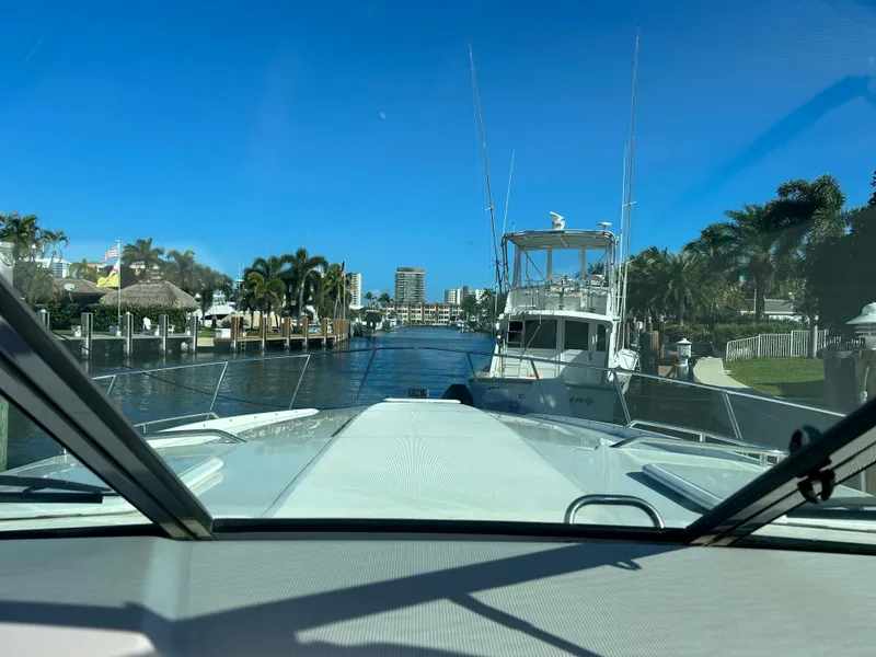 Slide: The Image of View from a 2001 Formula 41 PC boat navigating a sunny canal with palm trees. - 34