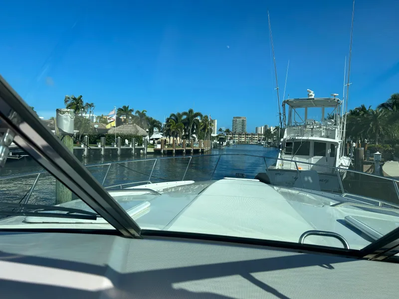 Slide: The Image of View from a 2001 Formula 41 PC yacht navigating a sunny, palm-lined waterway. - 36