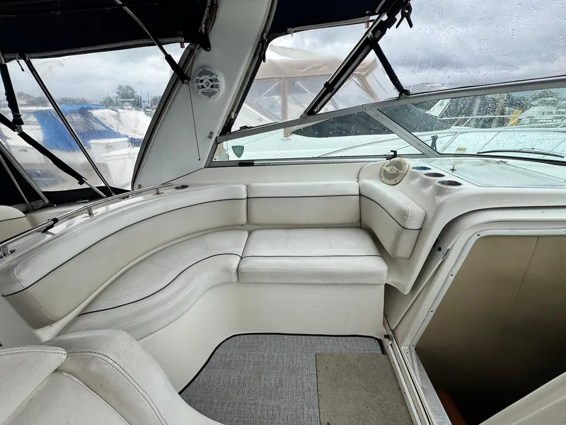 Slide: The Image of 2006 Rinker 342 Express Cruiser interior with white seating and large windows. - 11