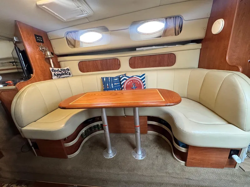 Slide: The Image of 2006 Rinker 342 Express Cruiser interior with beige seating and wooden table. - 12