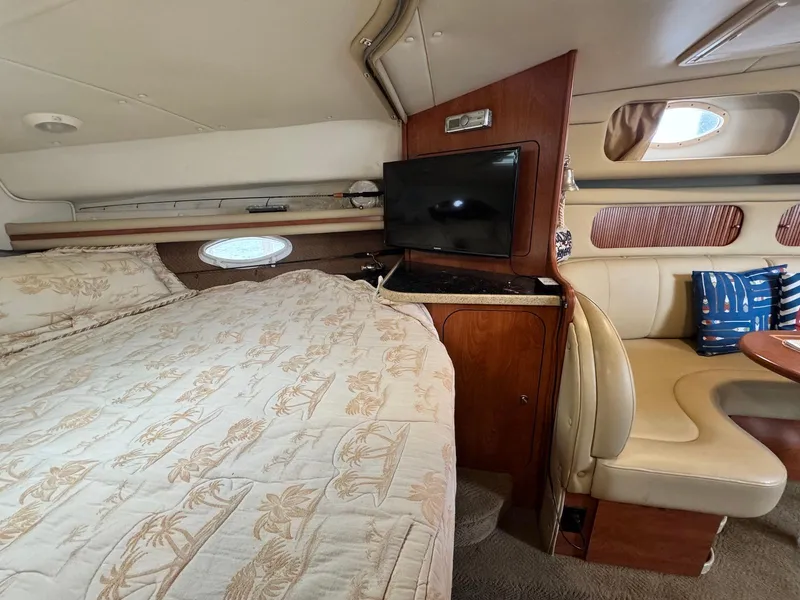 Slide: The Image of 2006 Rinker 342 Express Cruiser cabin with bed, TV, and seating area. - 15